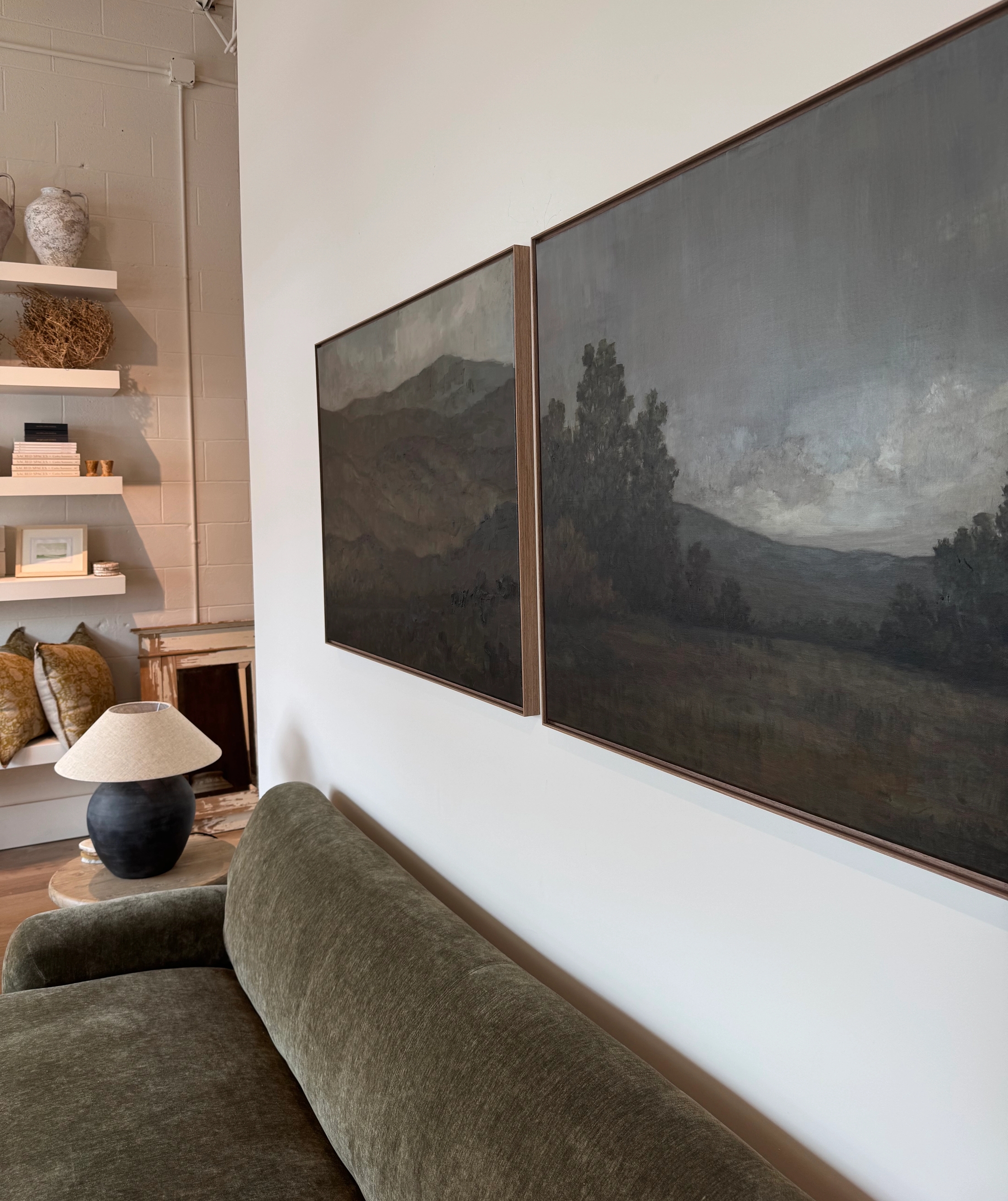 Two moody oil paintings above couch