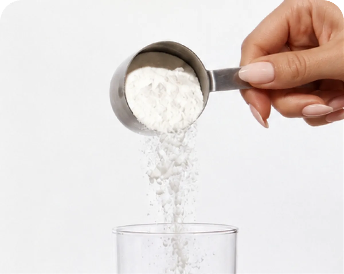 Creatine powder with a scoop and a glass of water
