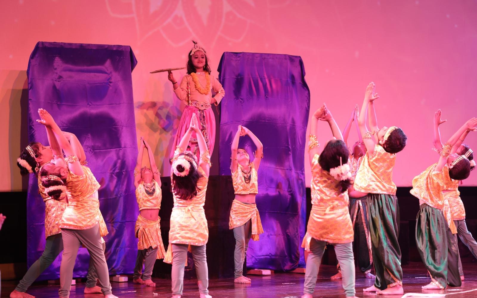 Children presenting a coordinated dance on stage