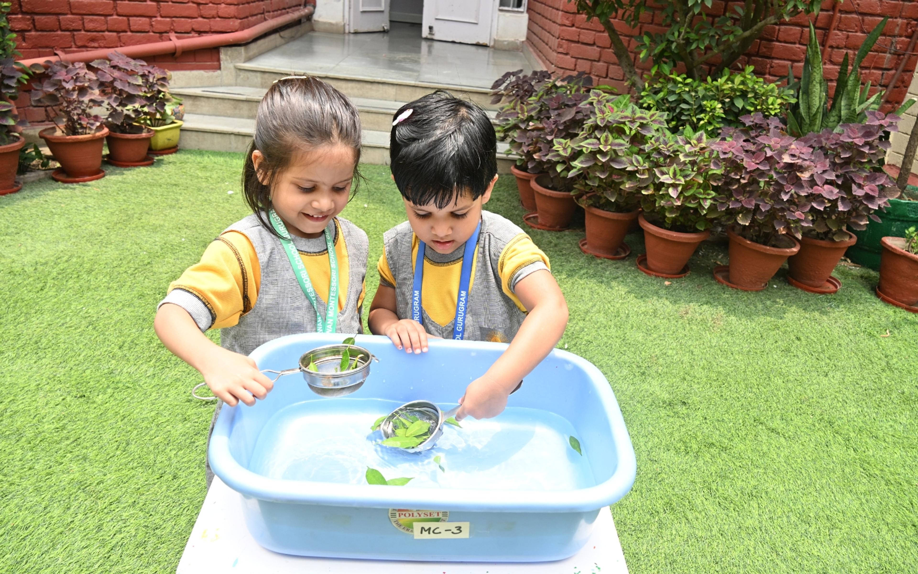 Two children exploring water and objects through sensory play