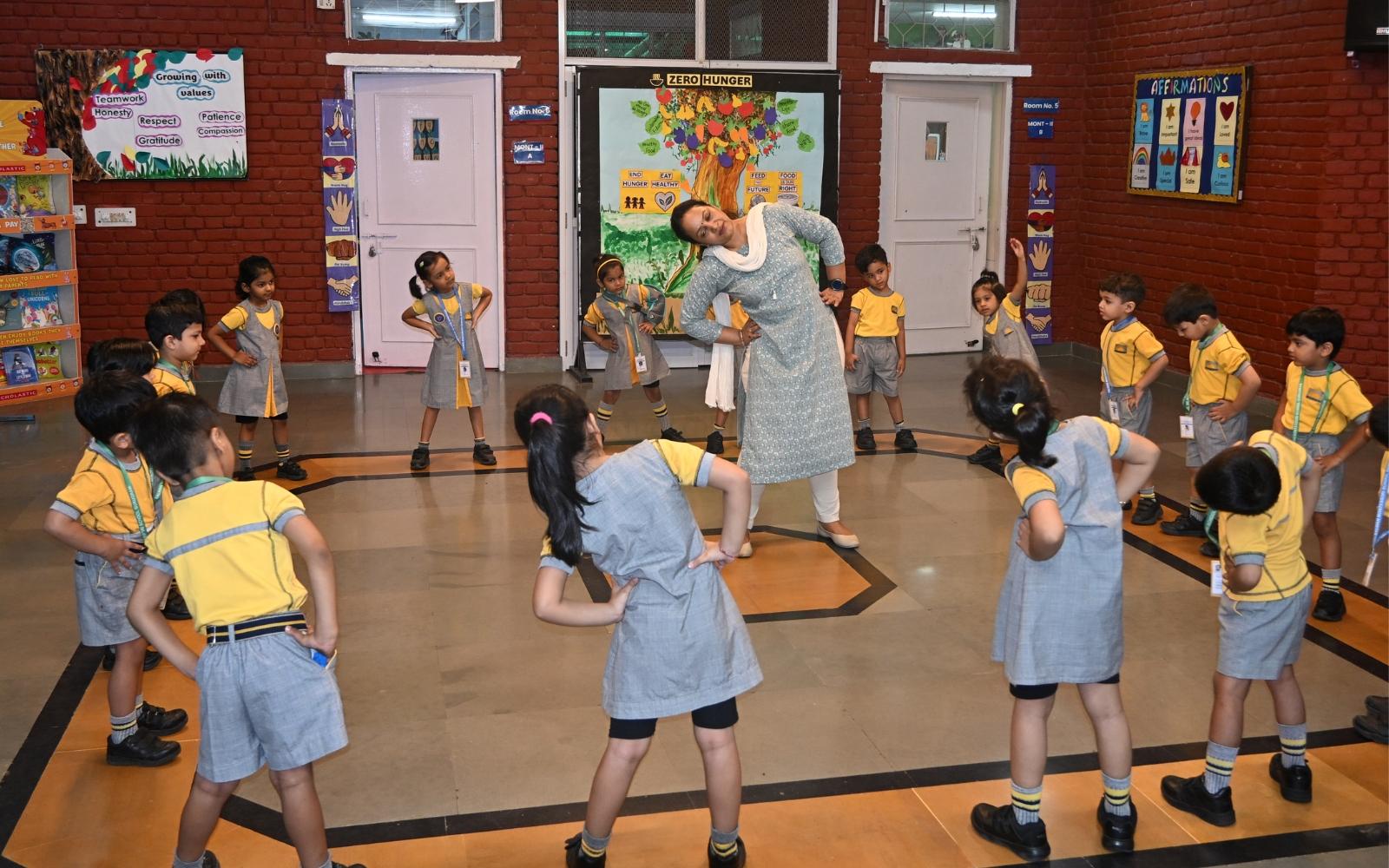 Children and a teacher dancing during an indoor movement activity