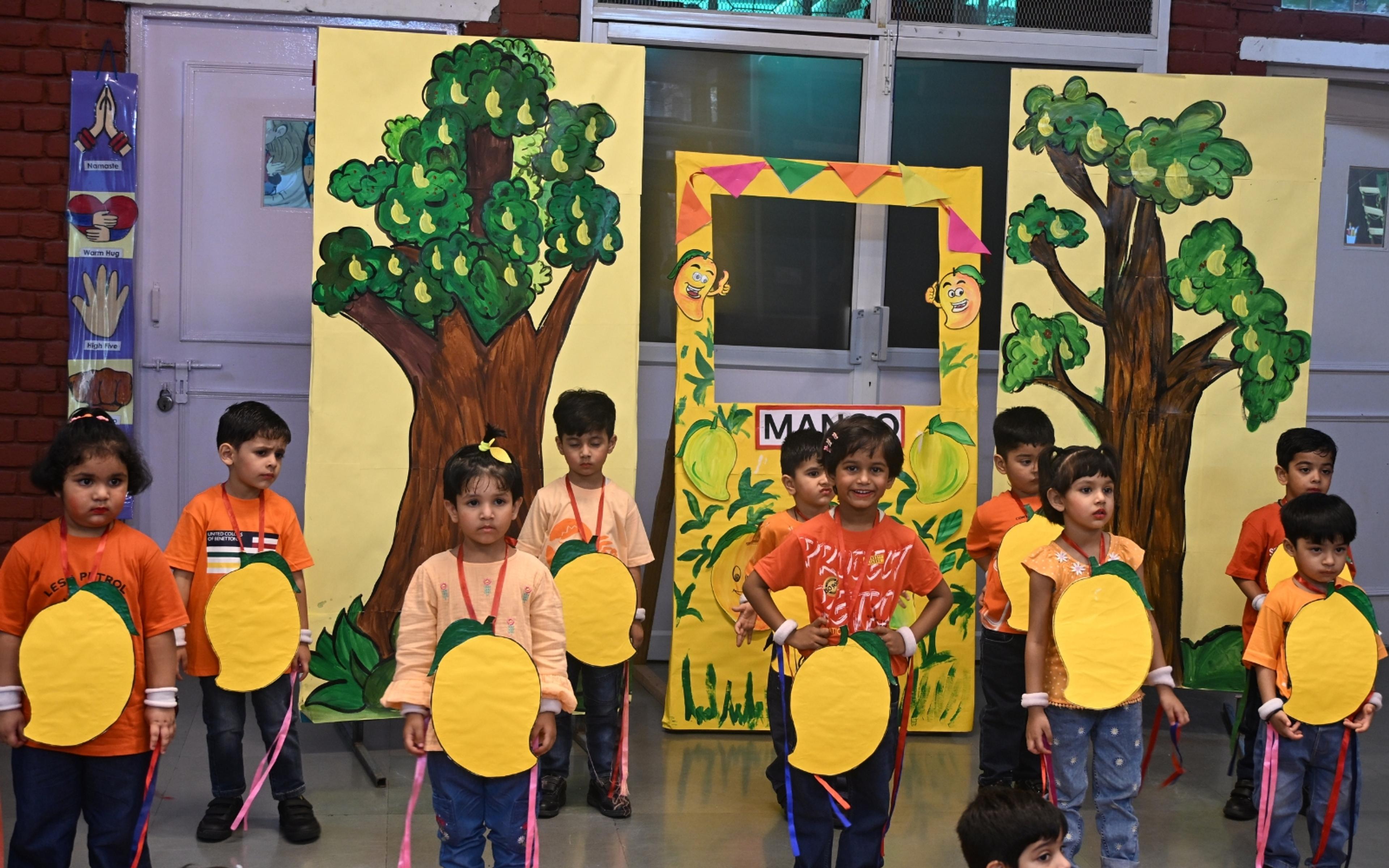 Children in orange costumes presenting a classroom performance