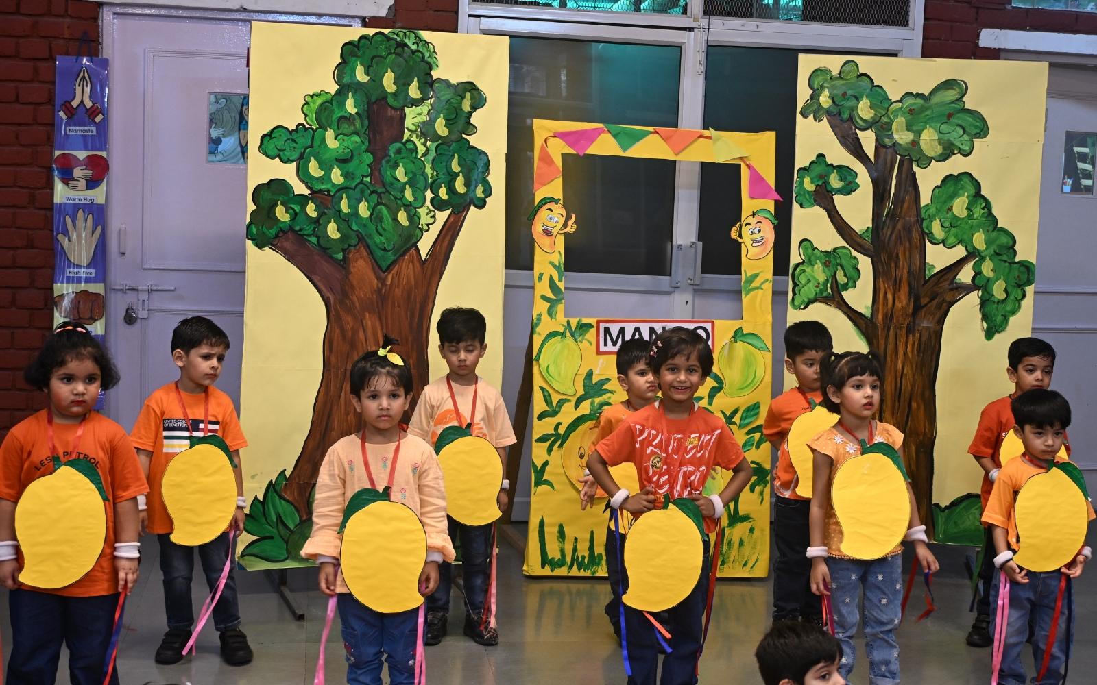 Children in orange costumes presenting a classroom performance