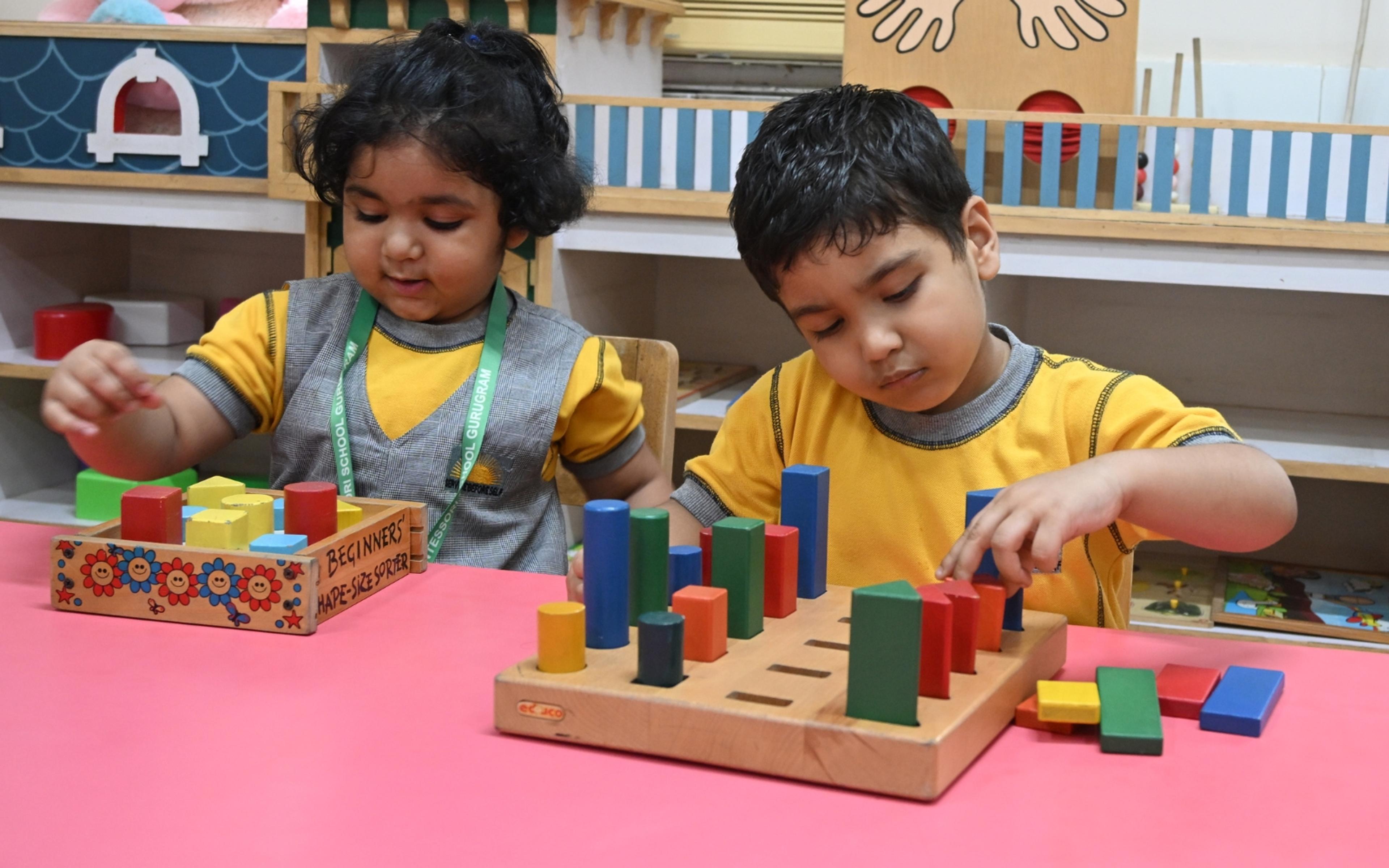 Children working with Montessori cylinder blocks