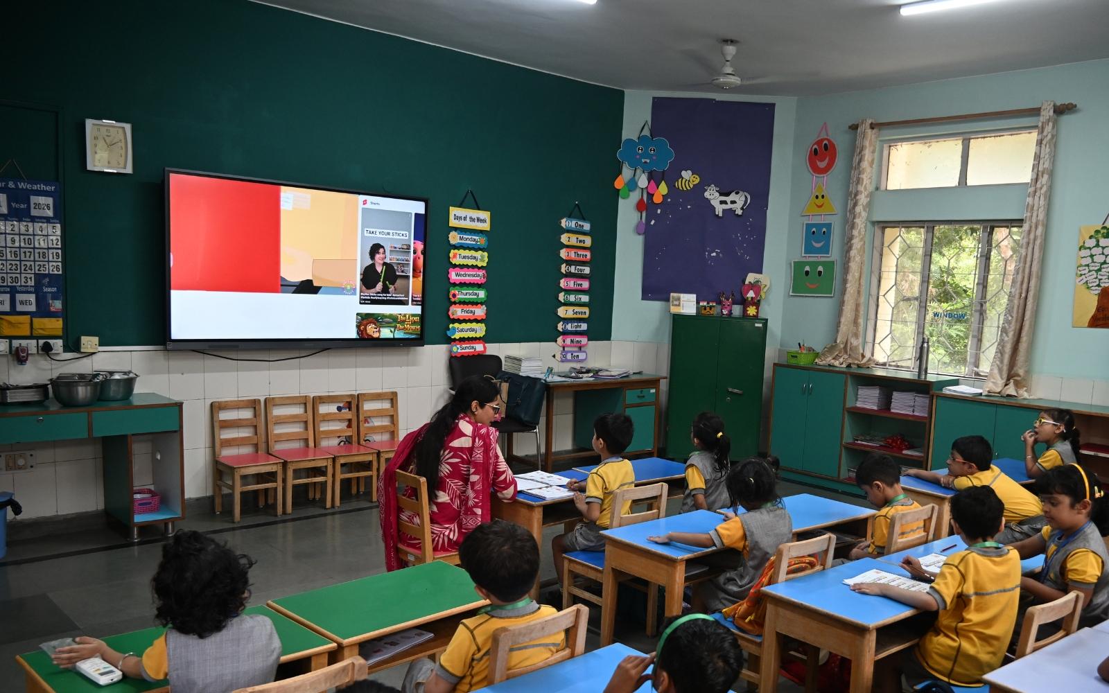 Children watching a lesson on an interactive classroom panel