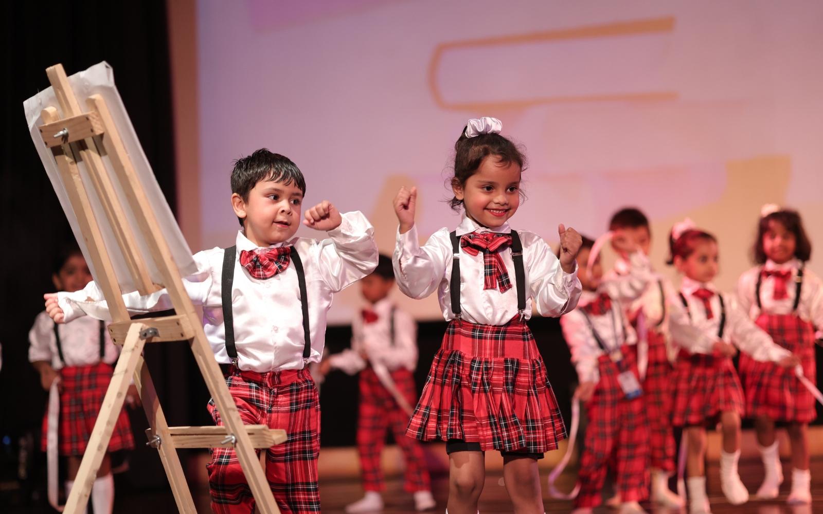 Two children taking part in an art-themed stage performance