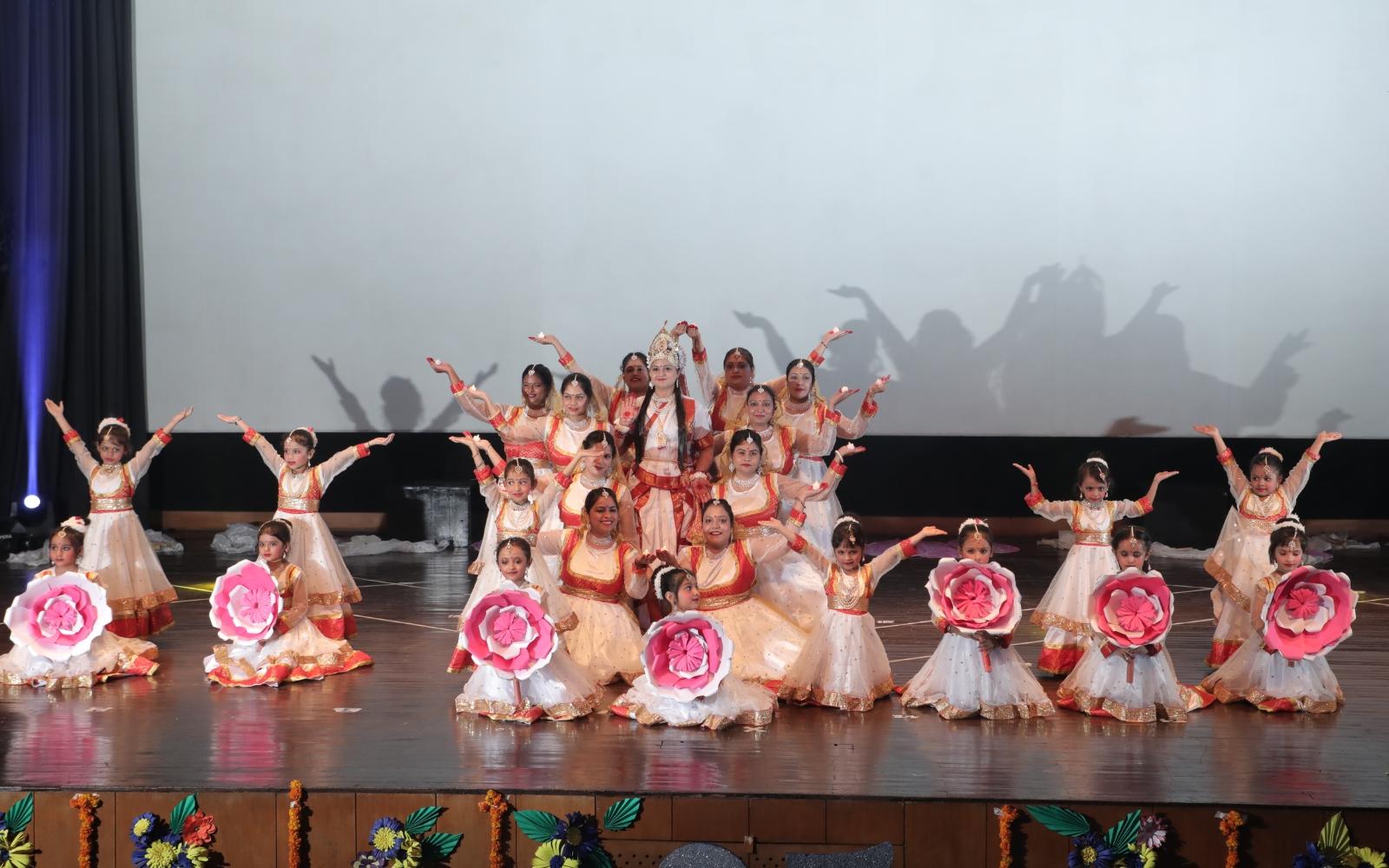 Children in flower costumes performing a dance on stage