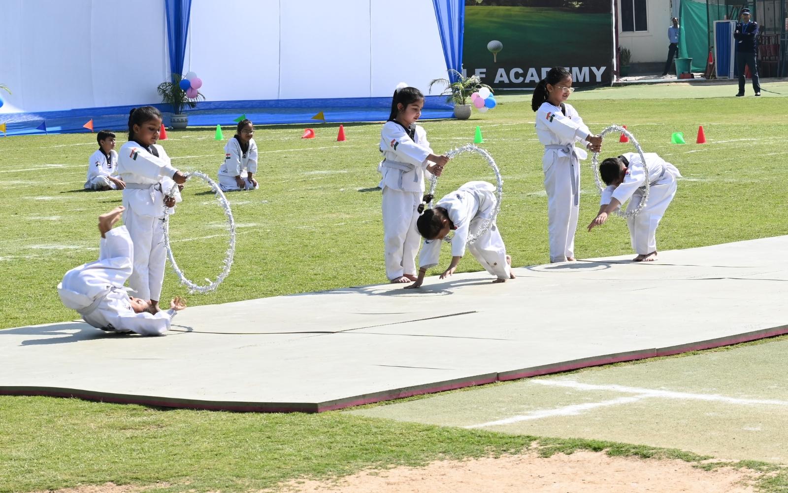 Children performing gymnastics with hoops on the school field