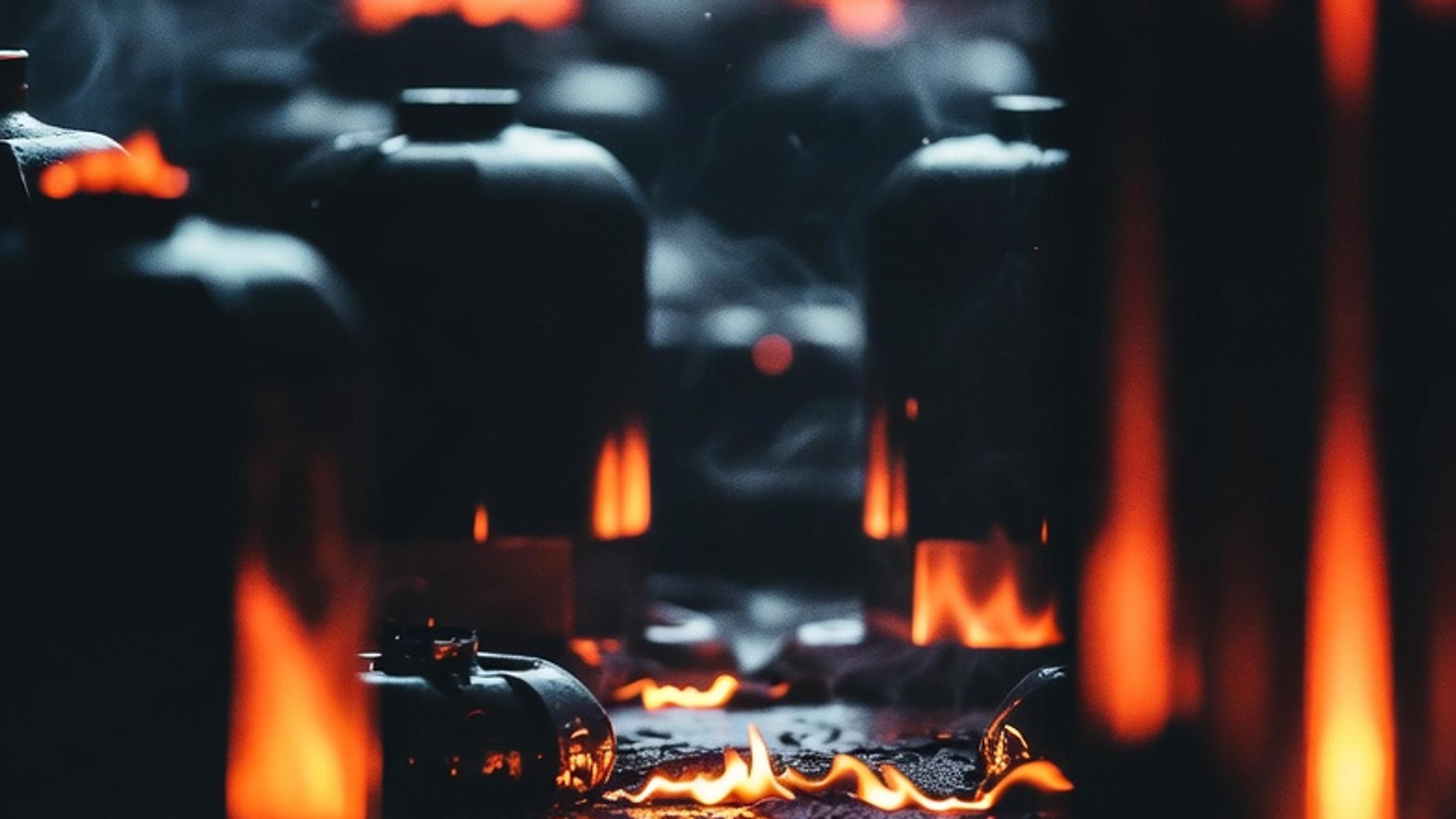 Glowing flames among dark industrial containers in a smoky environment