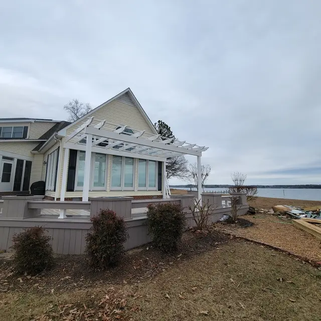 Wrap-around Deck on the River project after completion; A large deck with Timbertech Azek Harvest in Slate Gray and Timertech Azek Vintage Dark Hickory for the double border