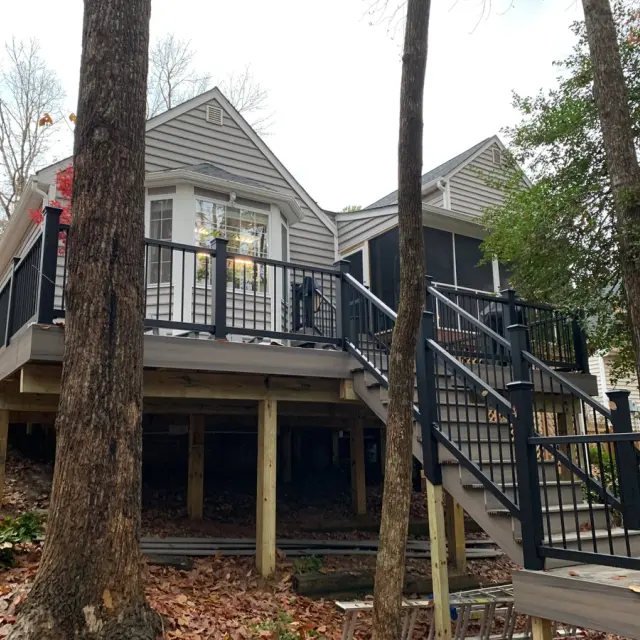 Upper and Lower Decks project after completion; Deck made of Trex Rocky Harbor with Black Trex Enhance Railings with stairs leading to lower deck in the backyard