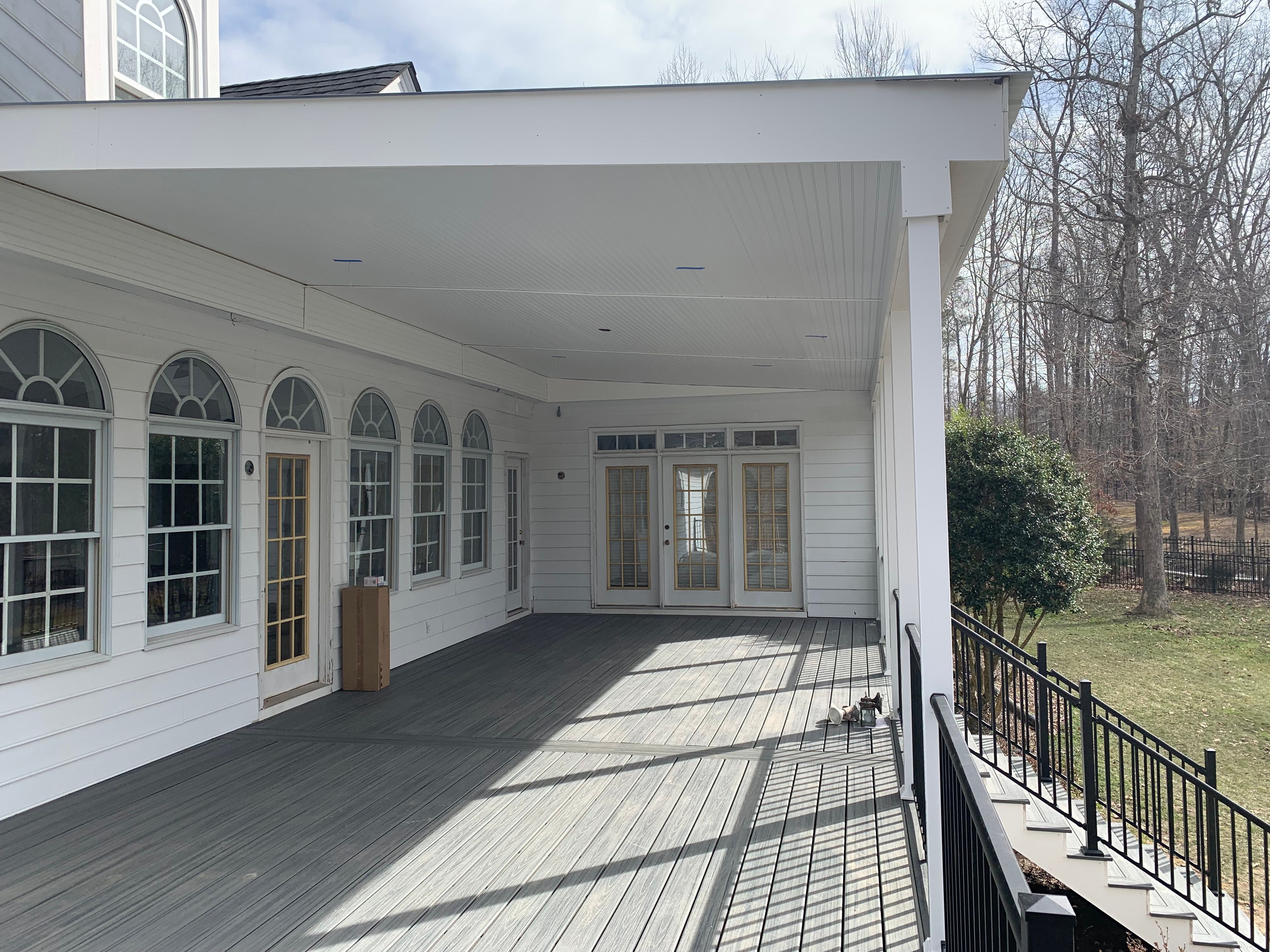 Large porch made of Trex Island Mist decking and black aluminum railings