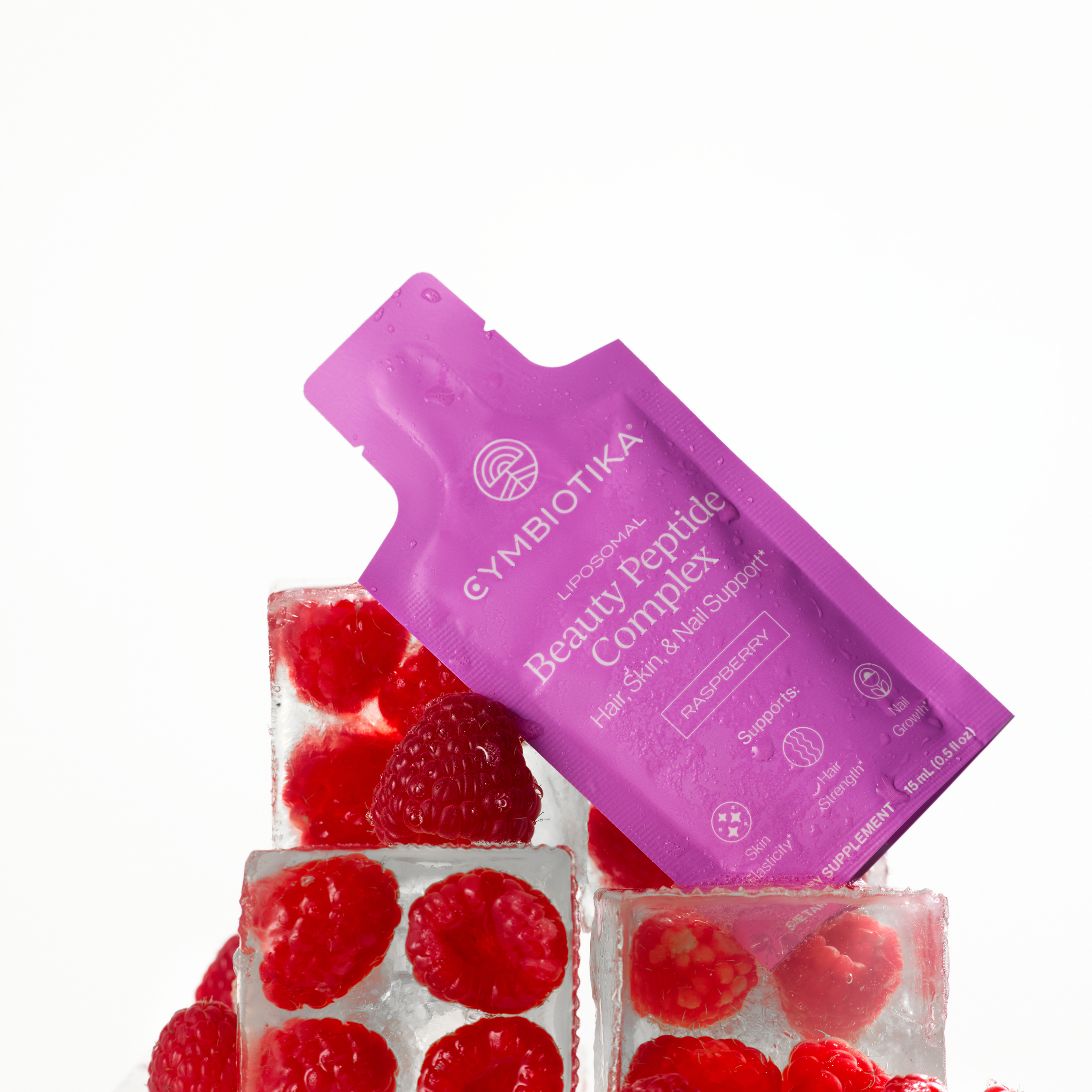 Liposomal Beauty Peptide Complex raspberry sachet resting on ice cubes with fresh raspberries.