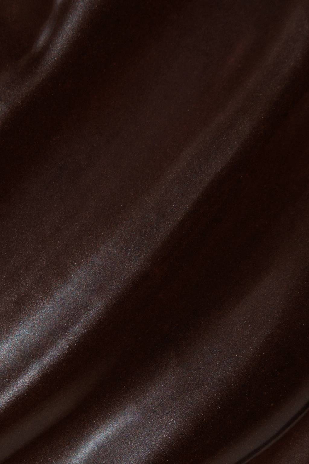 Close-up of a dark brown, subtly glossy surface with diagonal textured streaks.