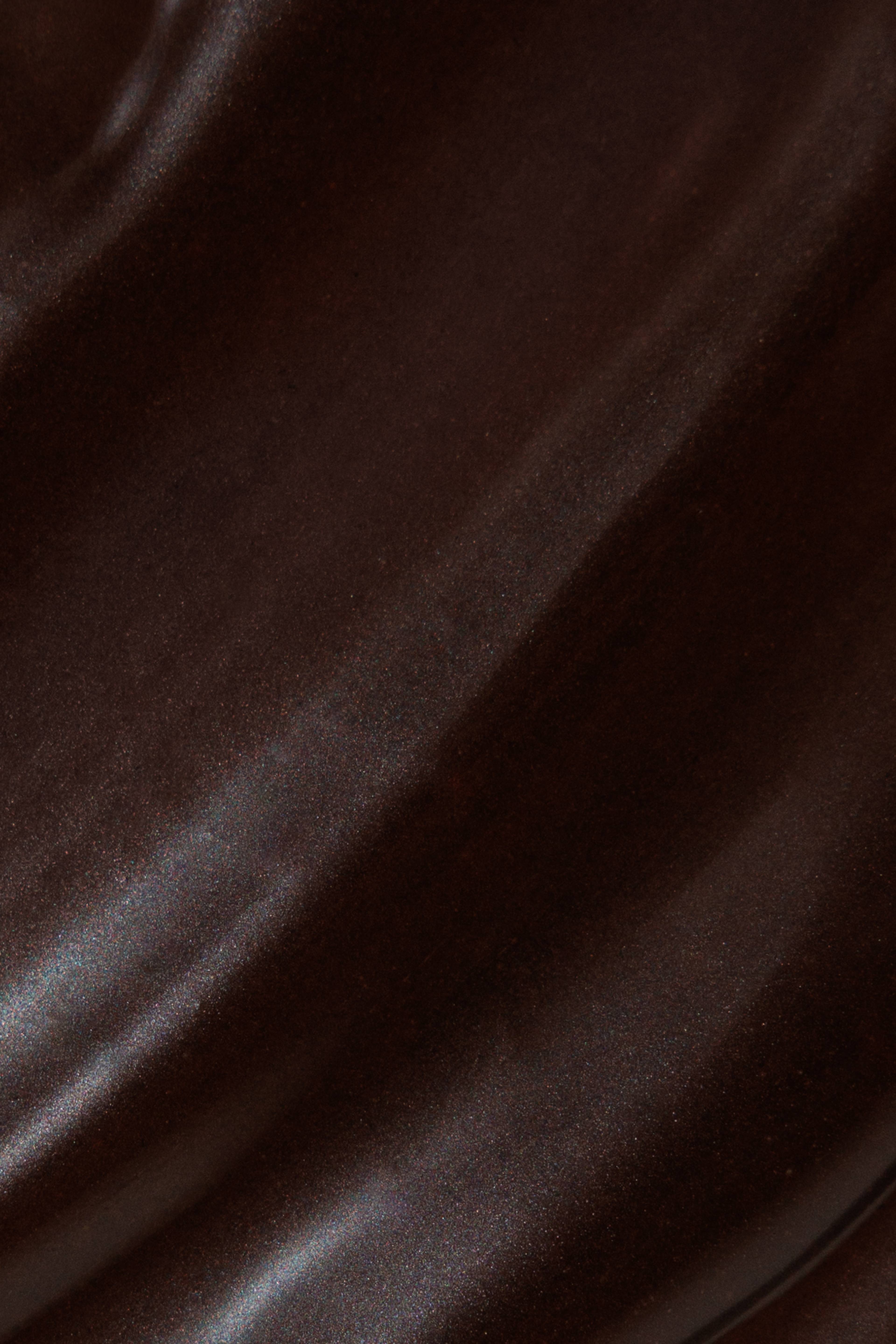 Close-up of a dark brown, subtly glossy surface with diagonal textured streaks.