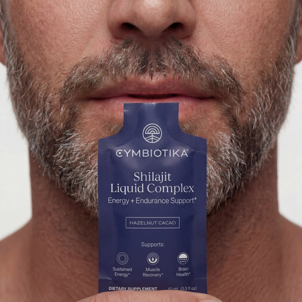 A man holds a Shilajit Liquid Complex sachet to his lips, showing its single-serving packet.