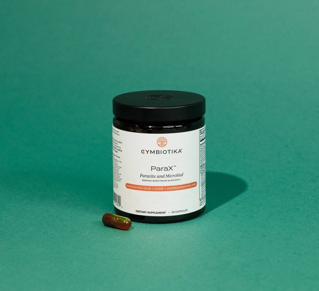 ParaX supplement bottle and a capsule on a teal surface.