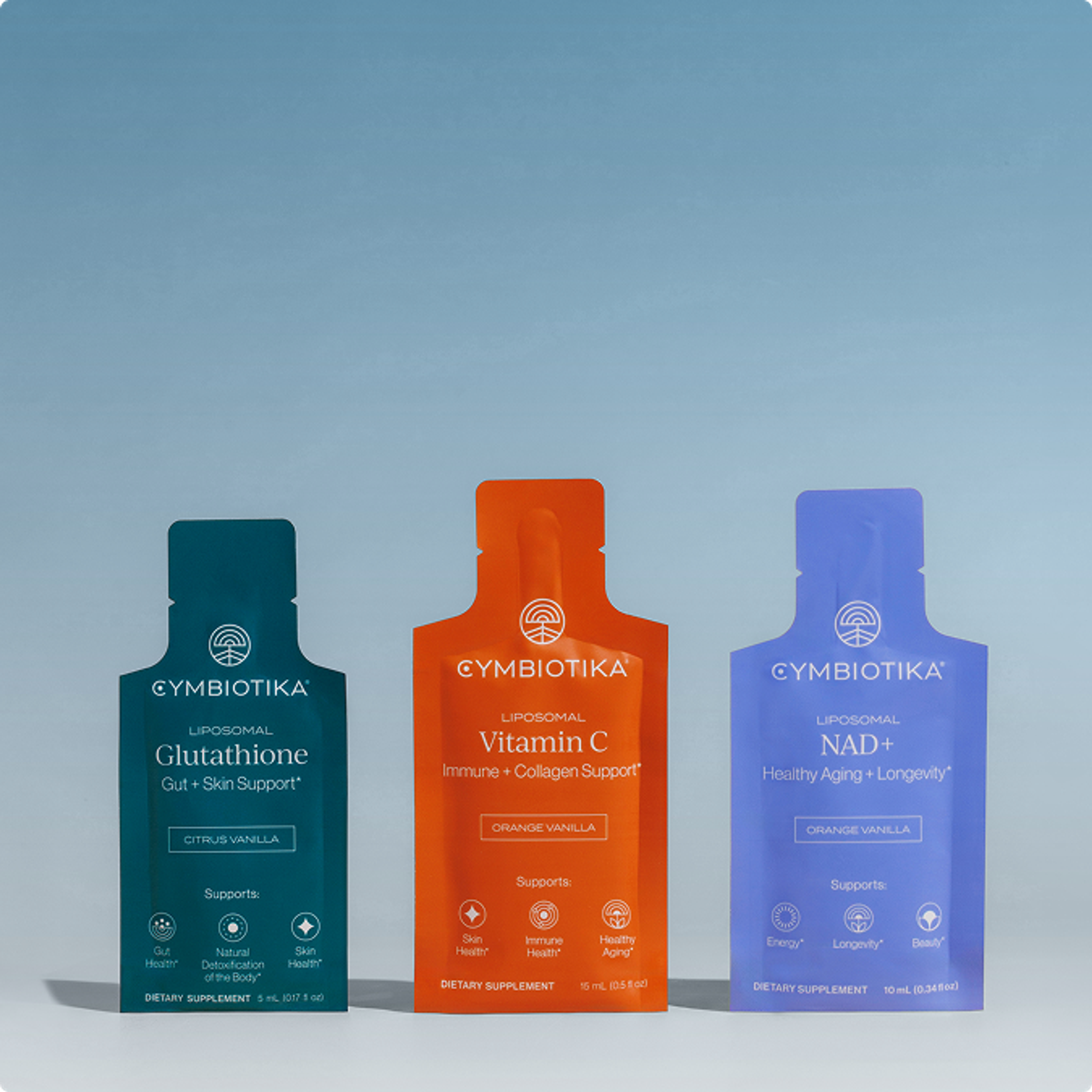 Three Cymbiotika supplement pouches—Glutathione, Vitamin C, and NAD+—stand against a pale blue backdrop.