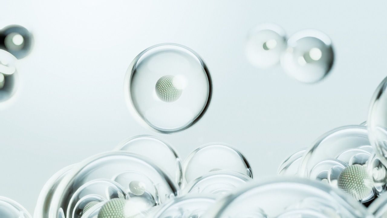 Translucent spheres, some holding textured particles, float against a pale blue background.