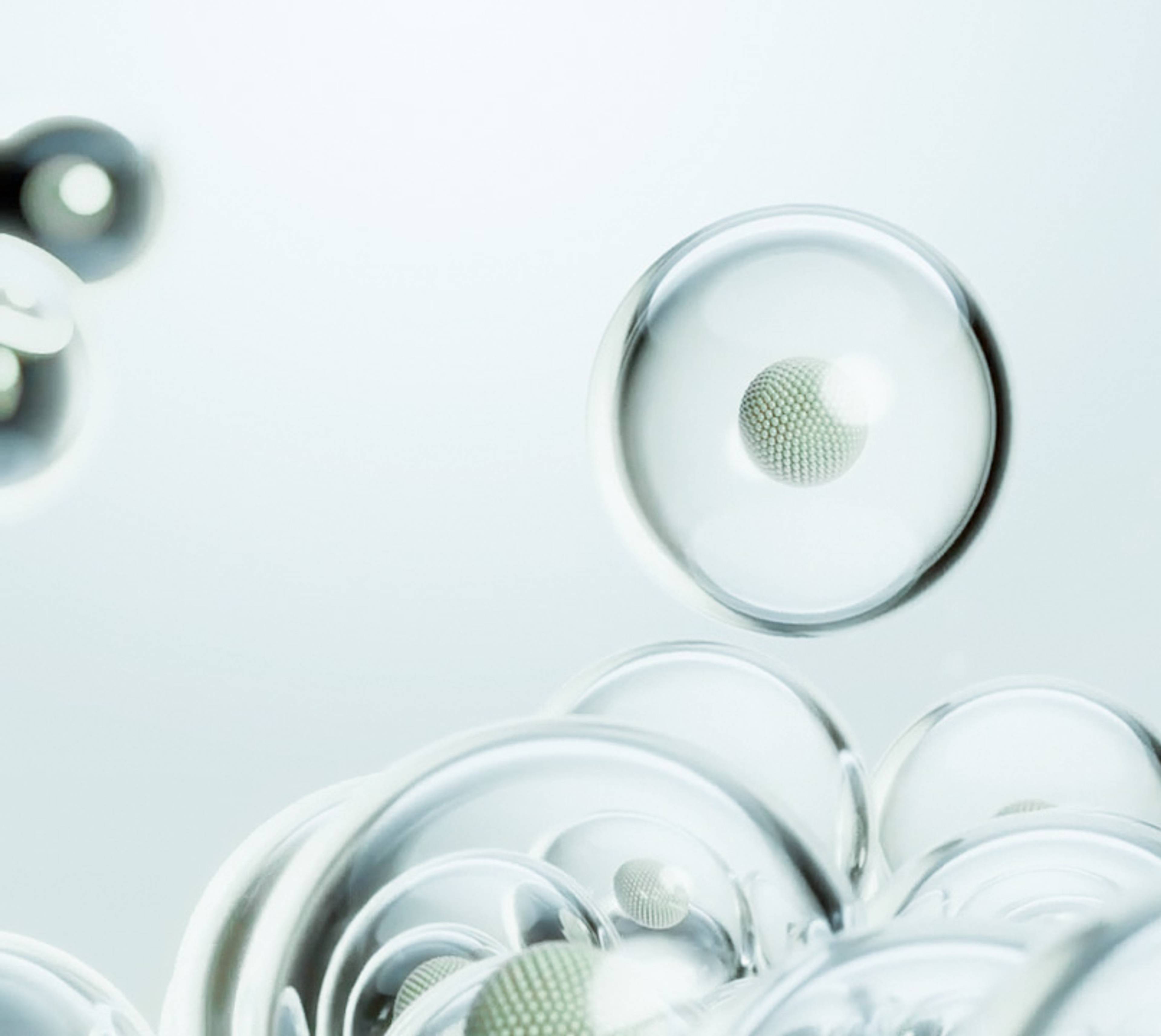 Translucent spheres, some holding textured particles, float against a pale blue background.