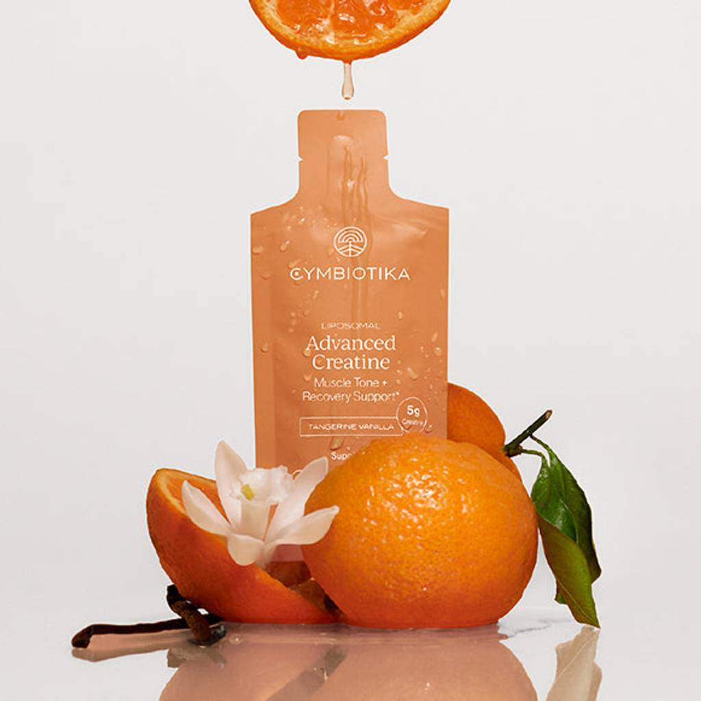 Cymbiotika Advanced Creatine sachet with oranges, a citrus slice, leaves, and white flower