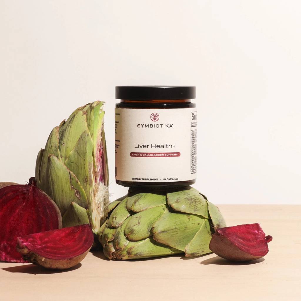 Liver Health+ supplement bottle displayed with artichokes and sliced beets.