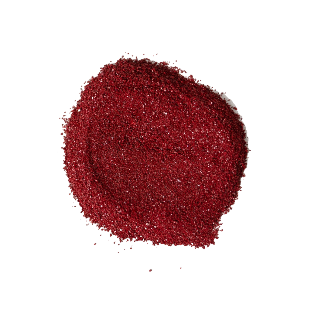 A mound of fine dark red granules, with a few scattered around its edges.