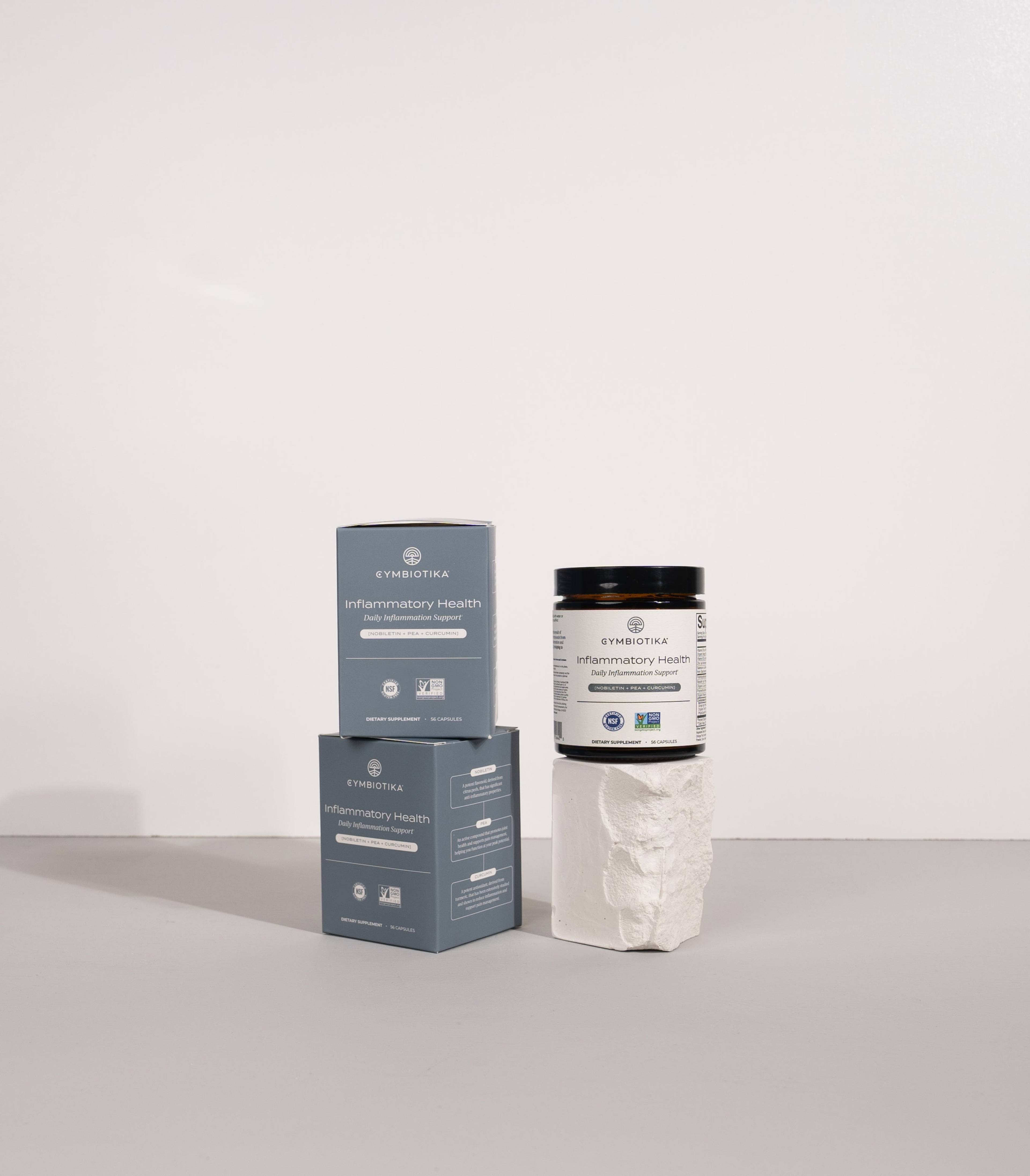 Inflammatory Health jar beside two matching boxes, displayed on a white pedestal.