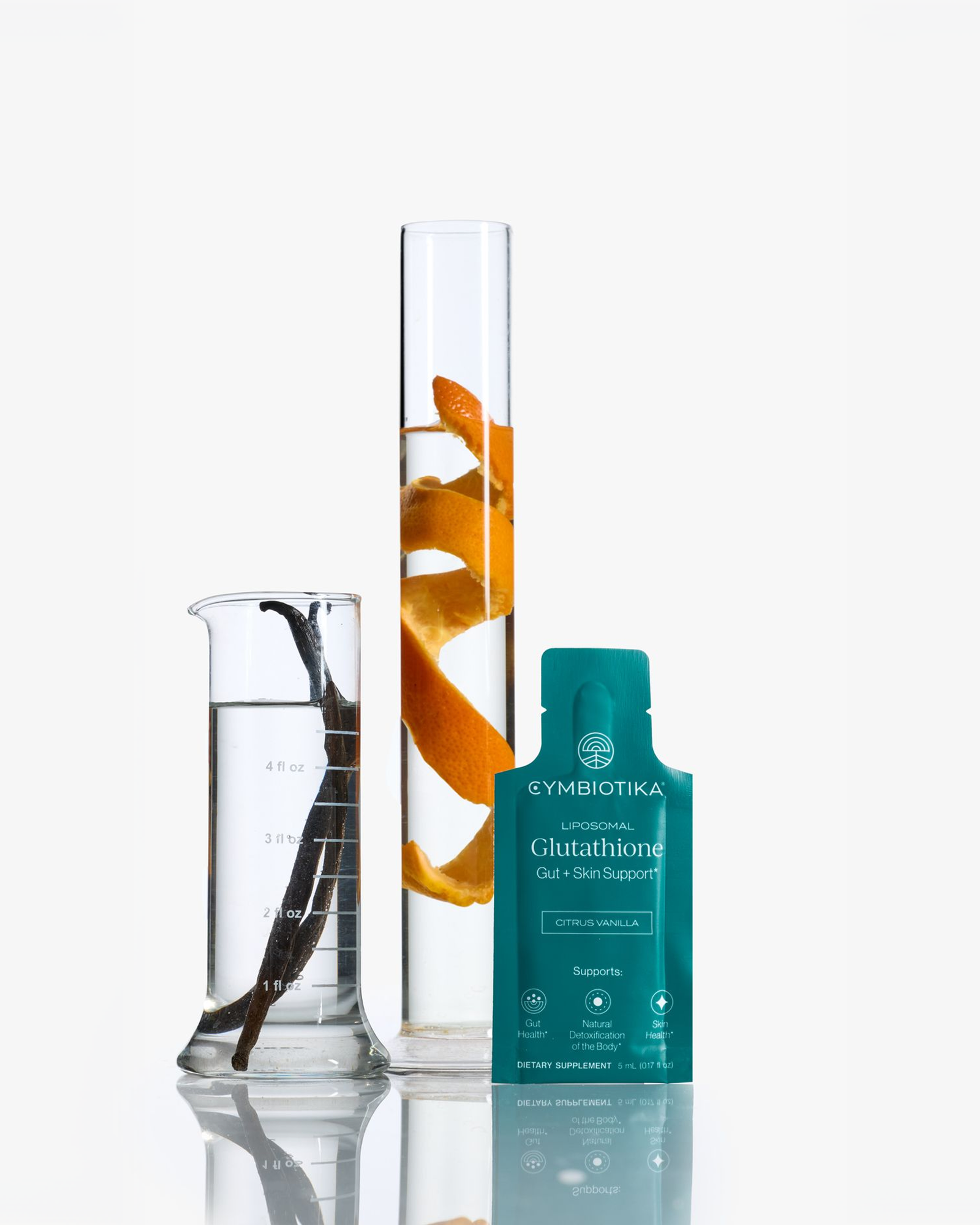 Teal Cymbiotika Liposomal Glutathione Citrus Vanilla sachet beside two graduated vessels with orange peel and a dark vanilla pod.