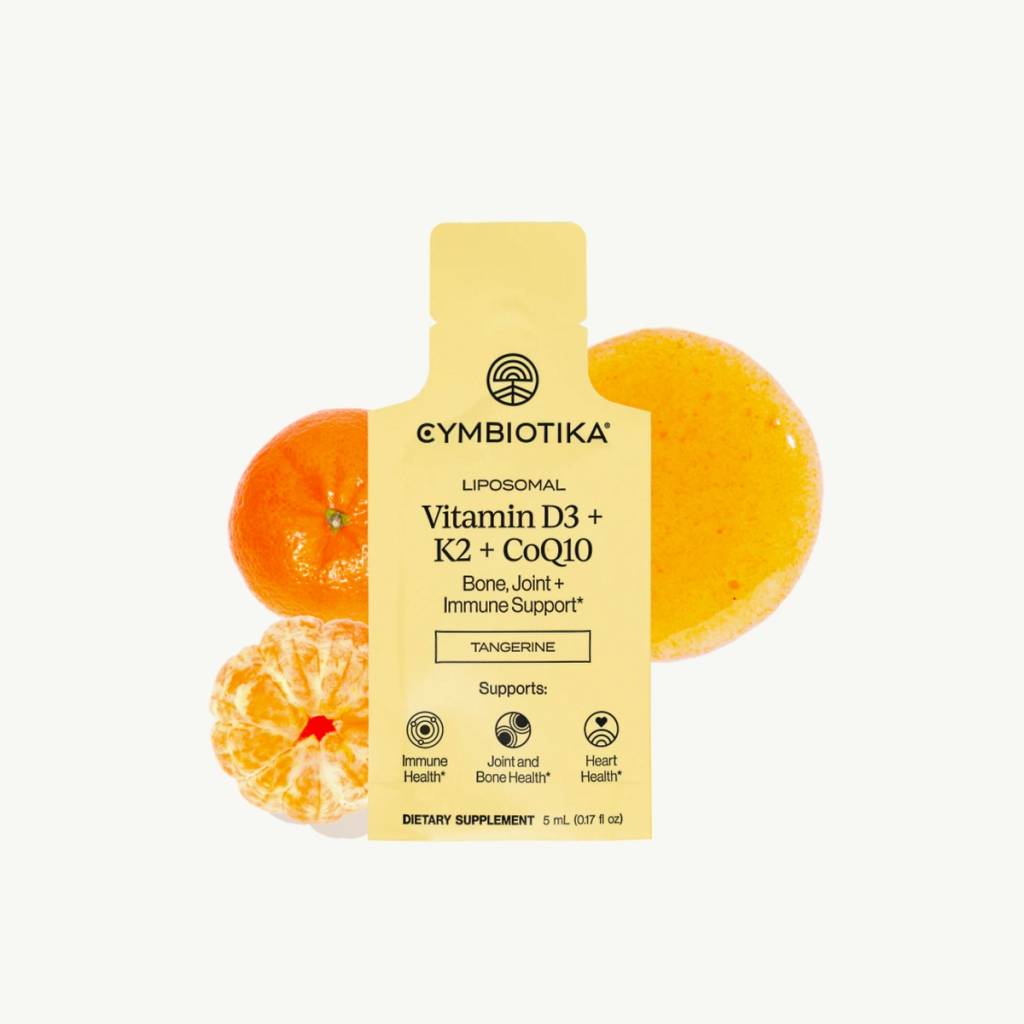 Yellow Liposomal Vitamin D3 + K2 + CoQ10 sachet displayed with whole and peeled tangerines.