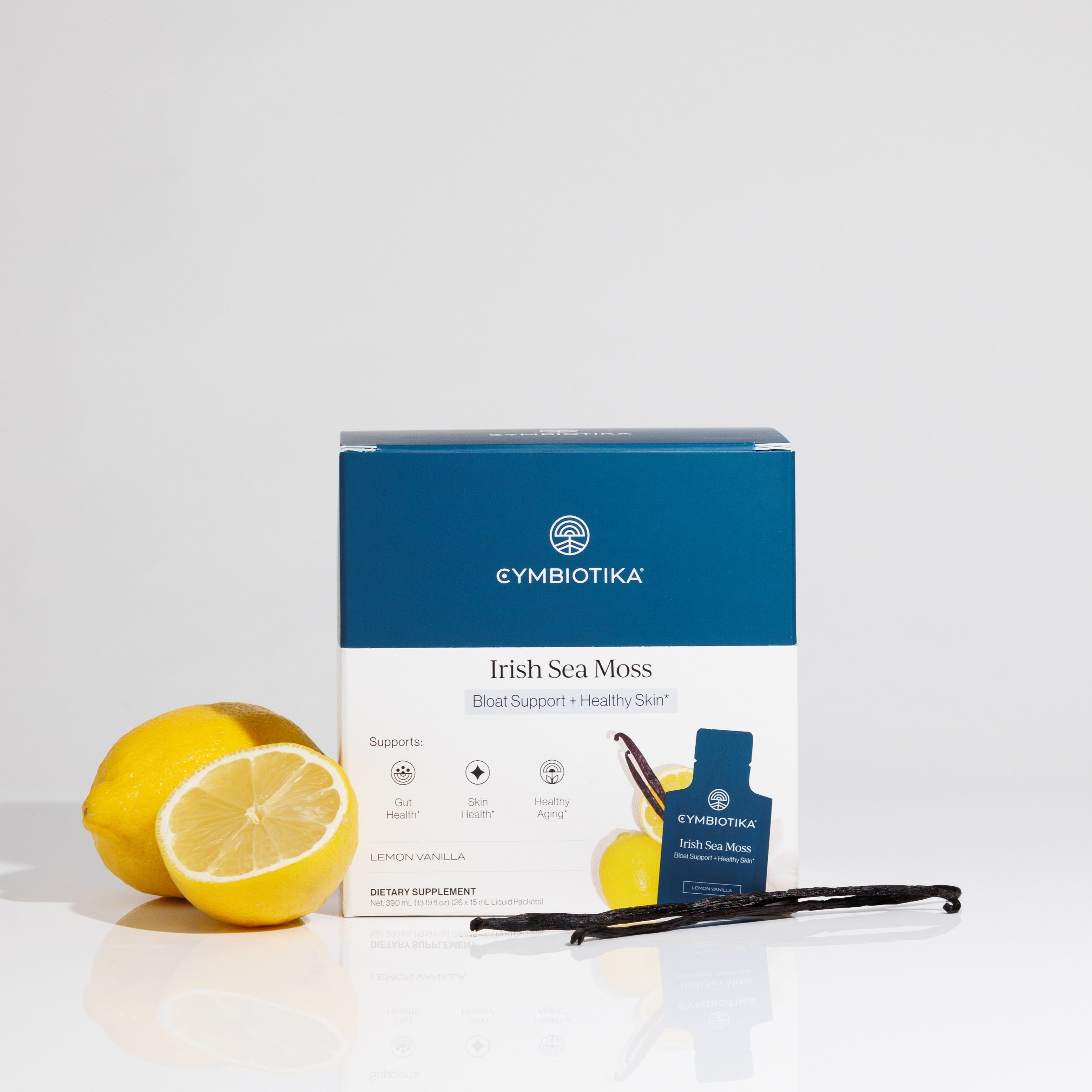 Cymbiotika Irish Sea Moss box and sachet with lemons and vanilla beans on a white surface.