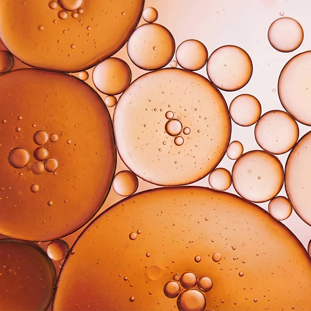 Close-up of amber and pale translucent droplets of varying sizes.