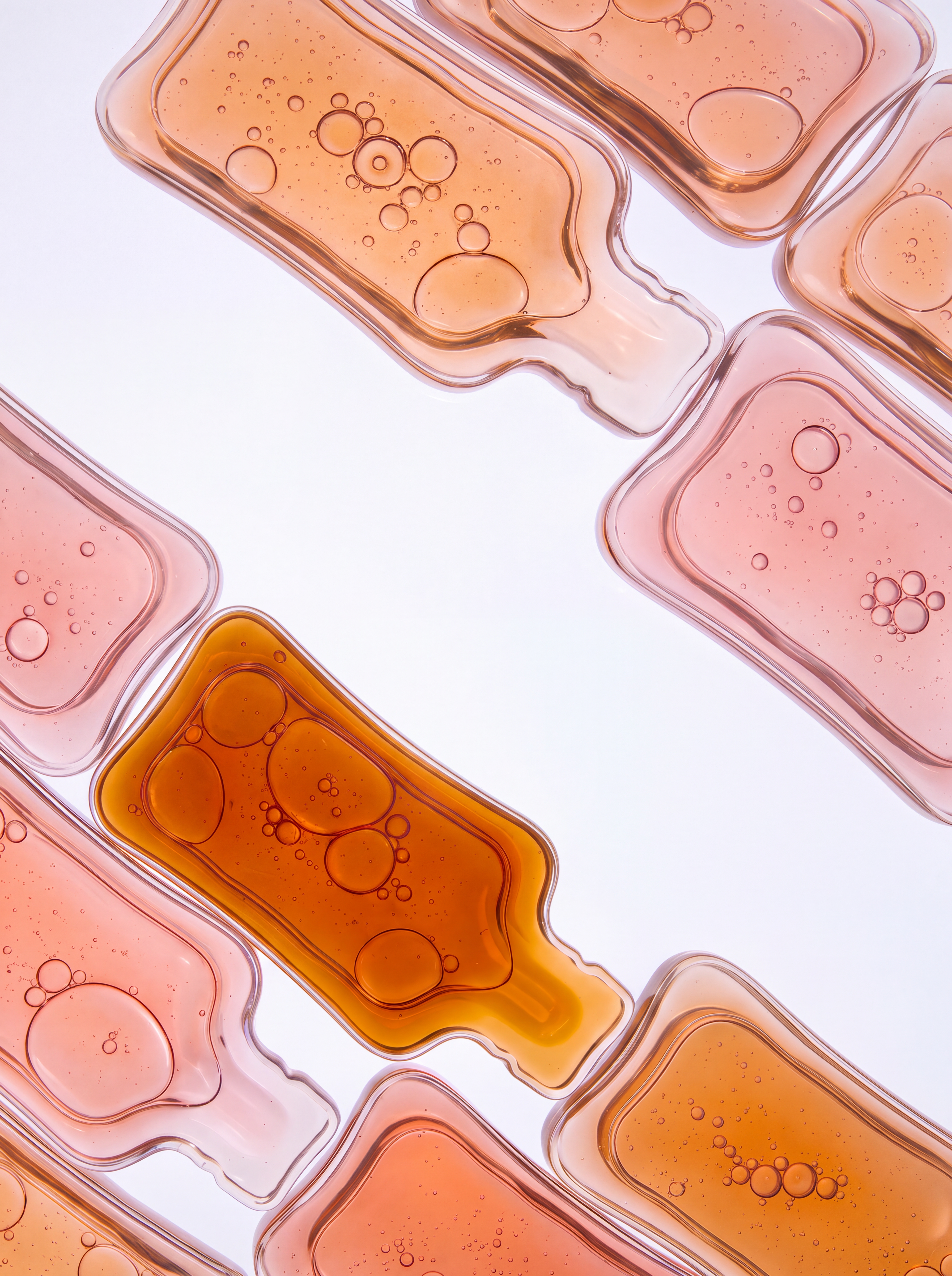 Abstract pink and amber rounded shapes filled with clusters of bubbles.
