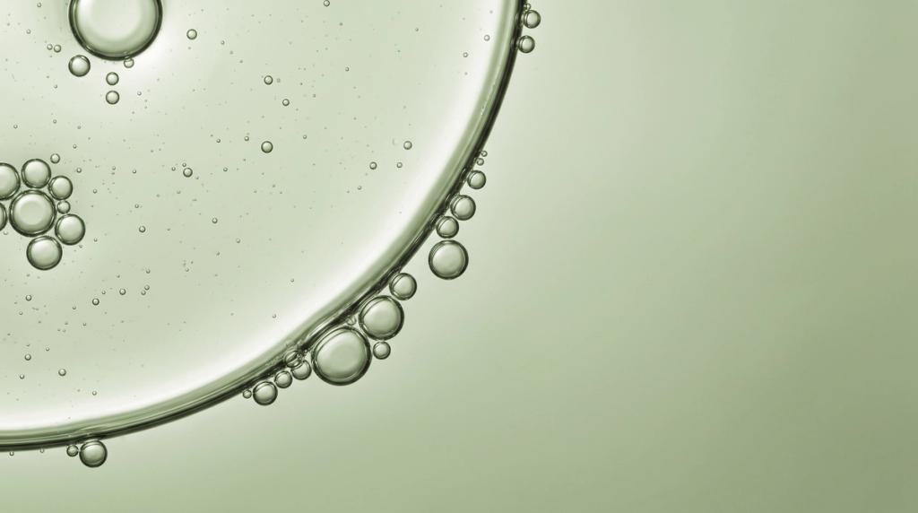 Macro view of bubbles along the curved edge of pale green liquid, serving as a background for a magnesium statistic.