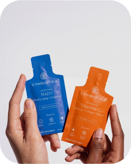 Hands hold blue Liposomal NAD+ and orange Liposomal Vitamin C sachets.