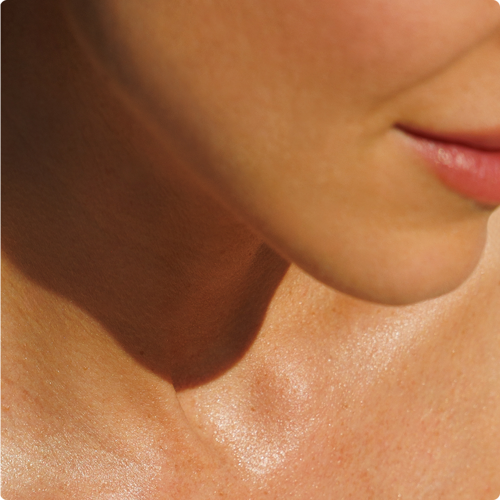 Close-up of a person's lower face, neck, and upper chest, showing skin texture.