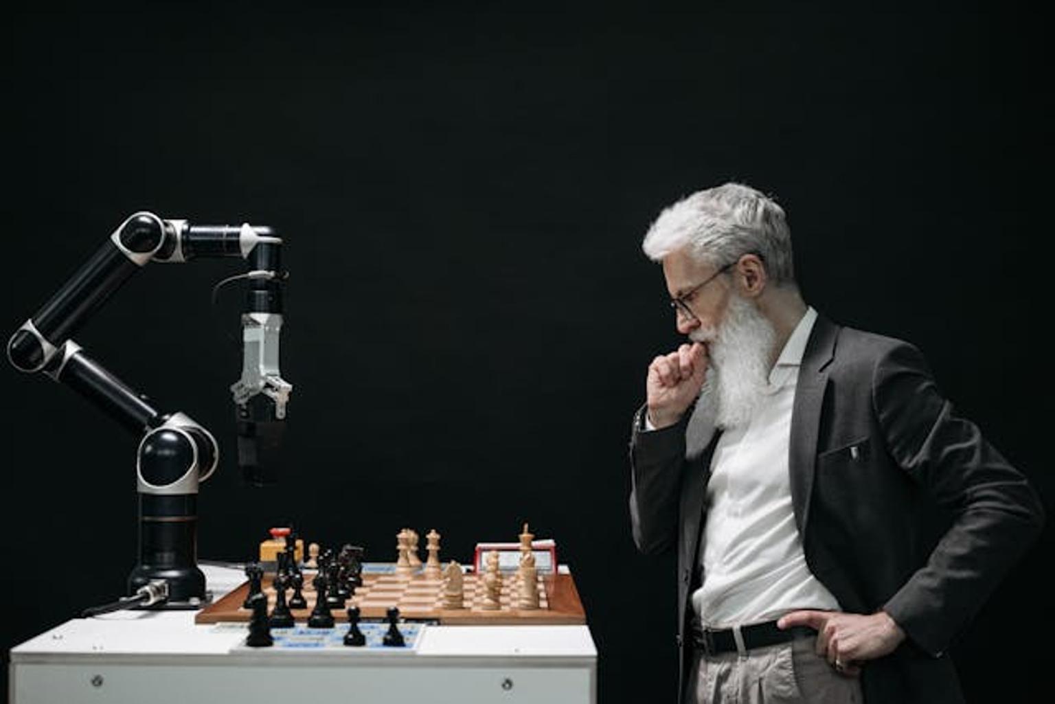 Old man playing chess with an automatic robot arm using AI technology for navigation