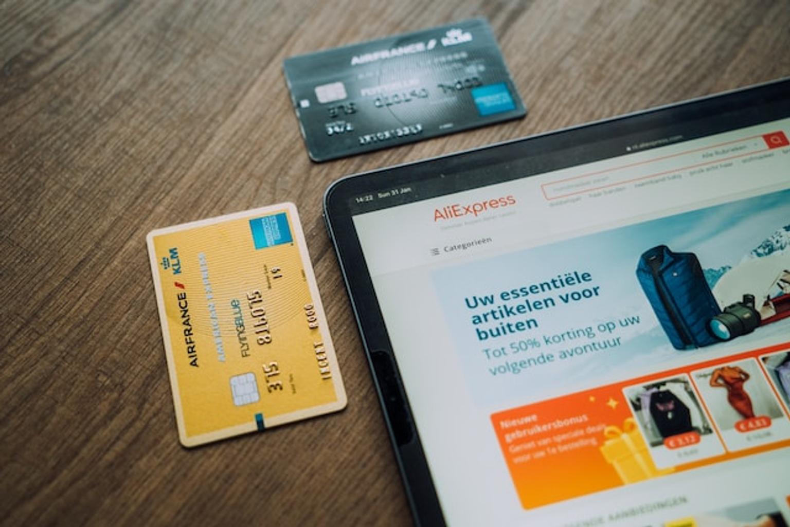 A tablet displaying Aliexpress site beside multiple credit cards.
