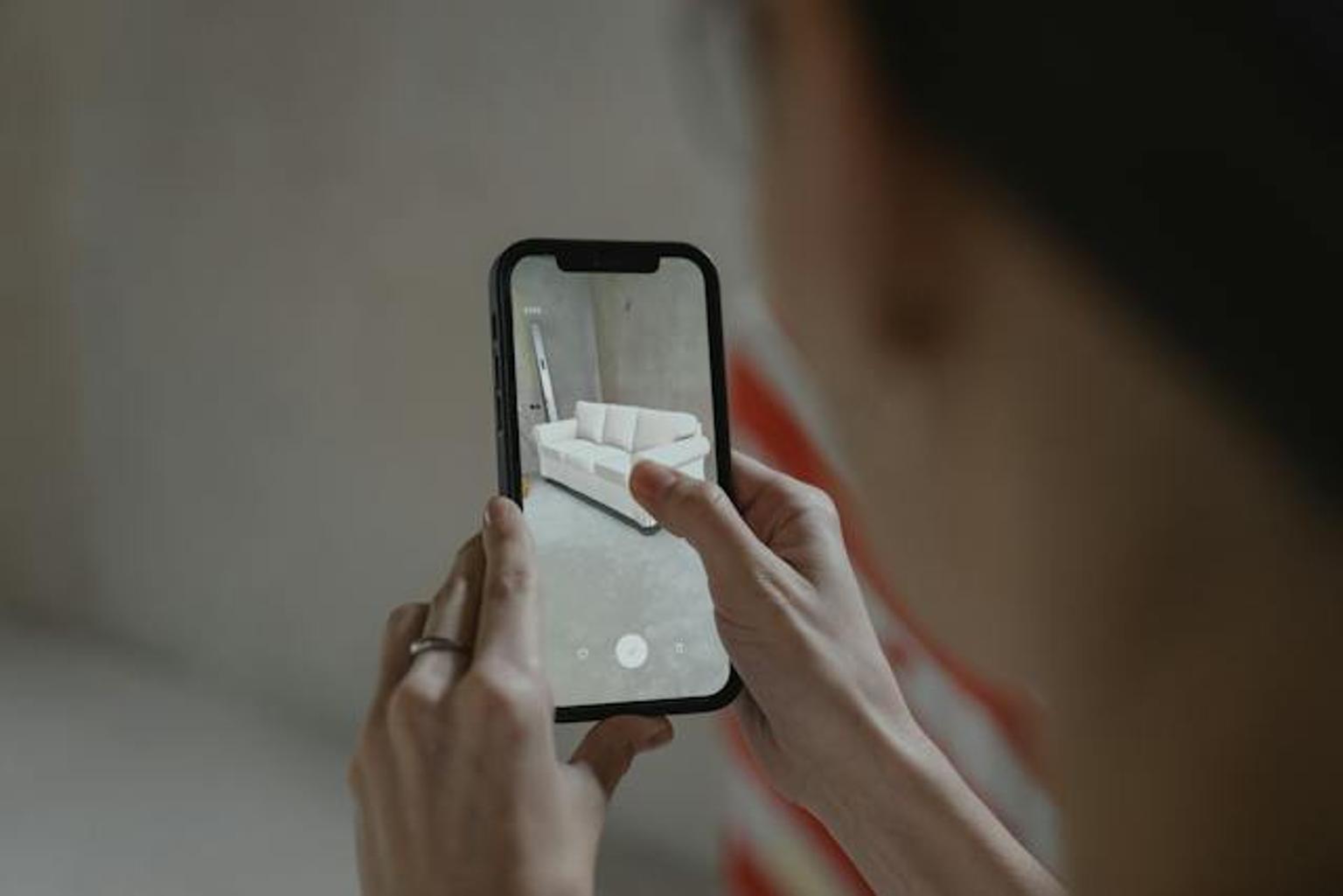 Woman planning her furniture placement in her apartment using AR software.