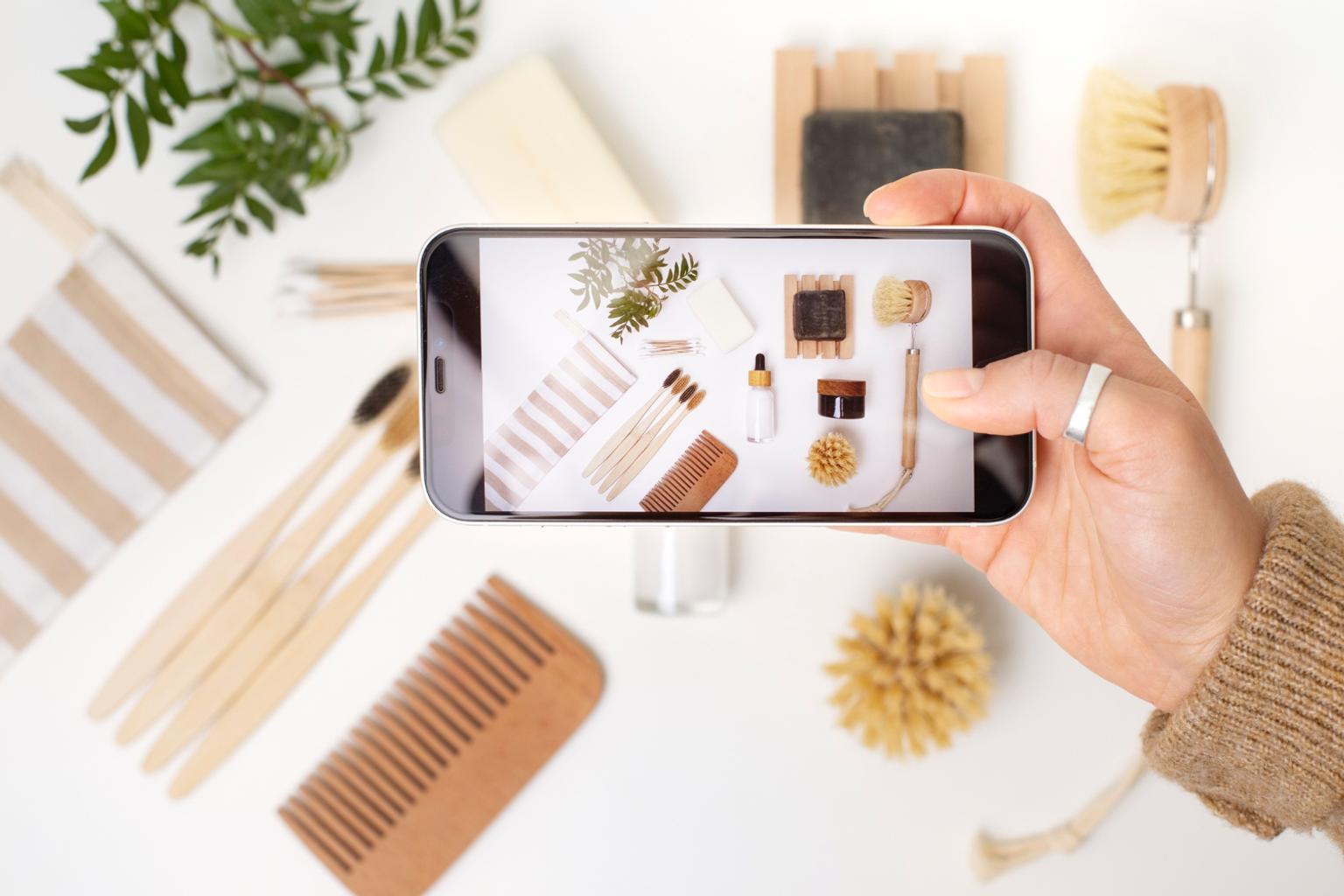 Women taking a photo with smartphone of handmade items for her Etsy shop