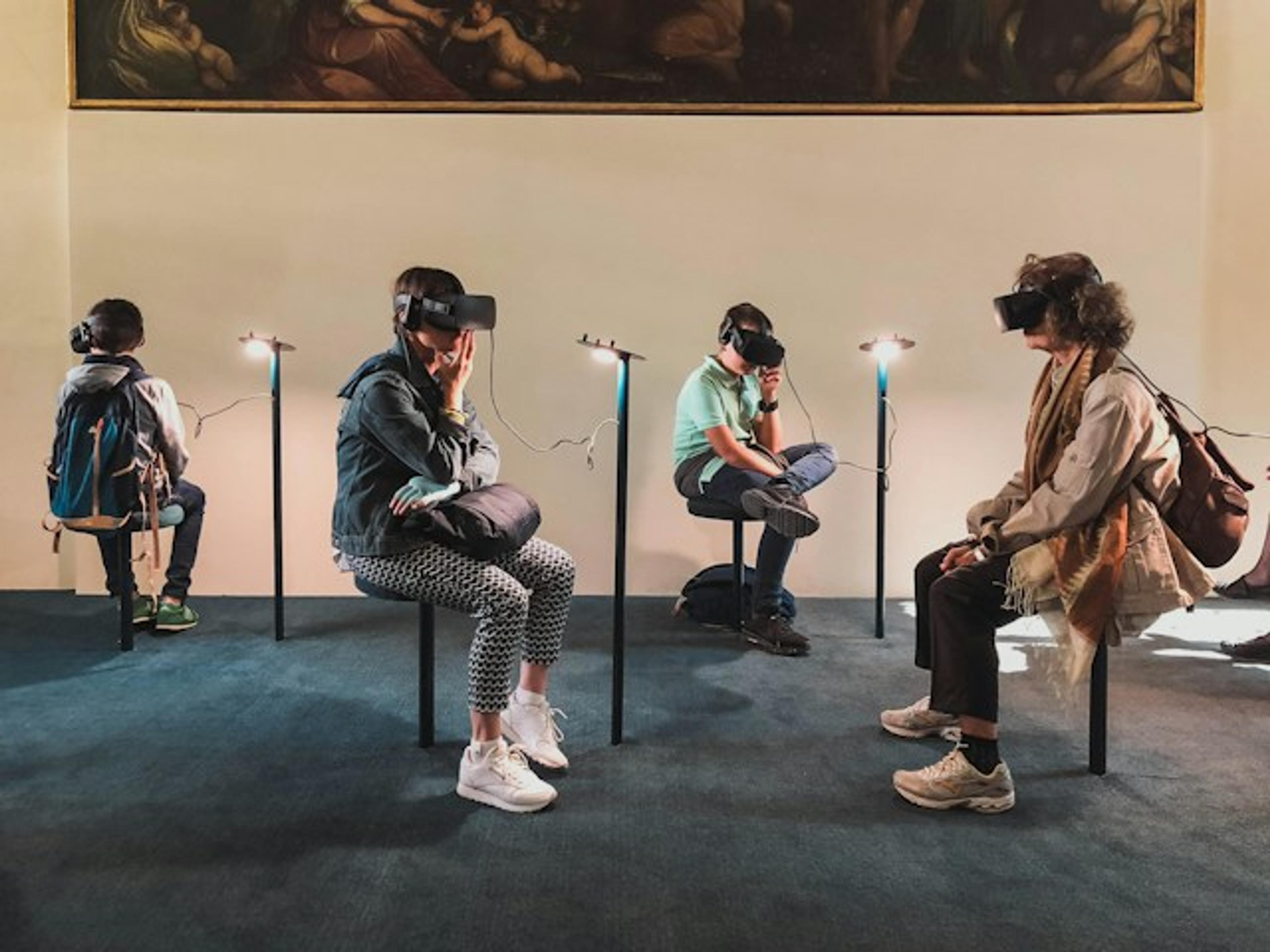 People sitting and wearing VR headsets in a room.