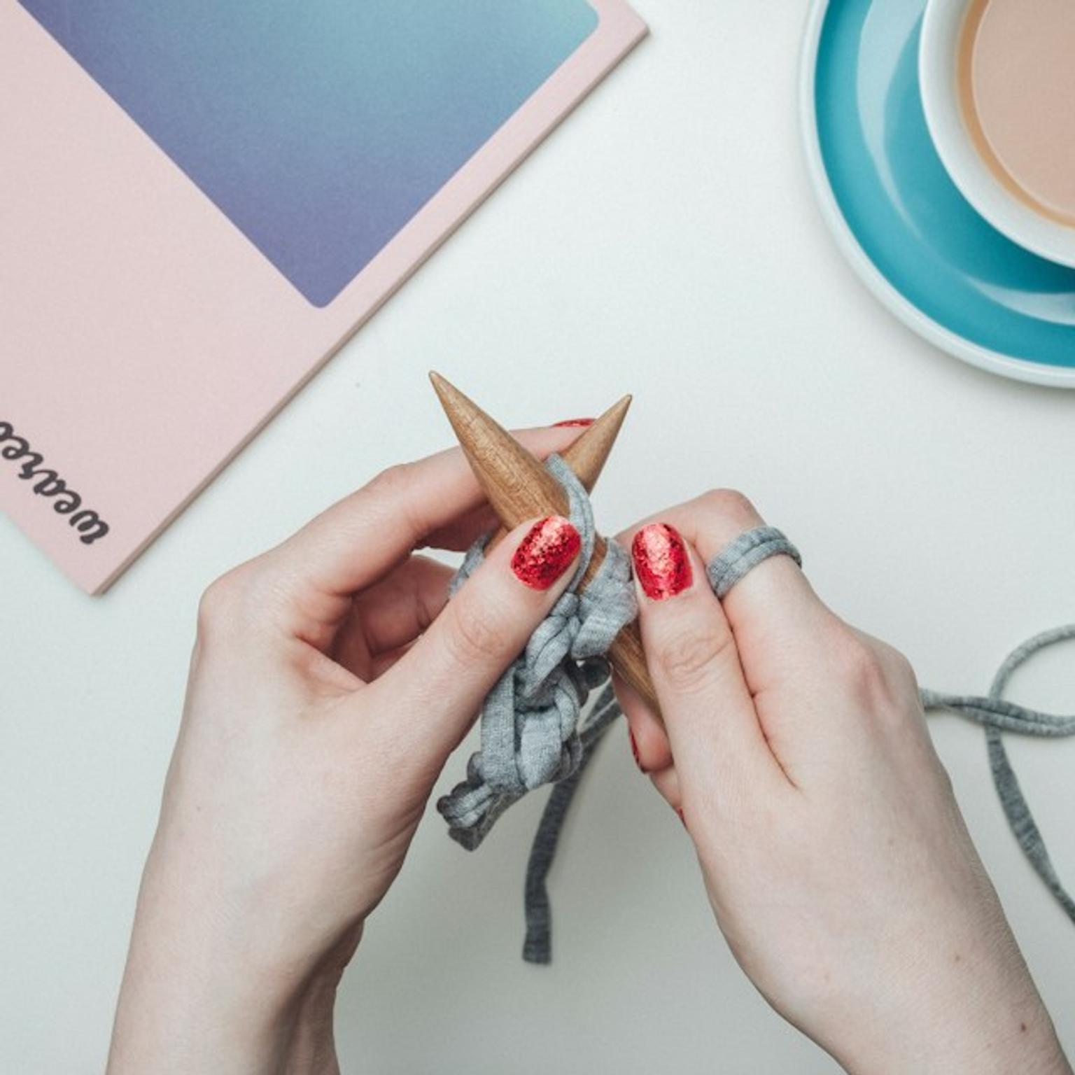 Image of a women's hand creating DIY handmade item over a table.