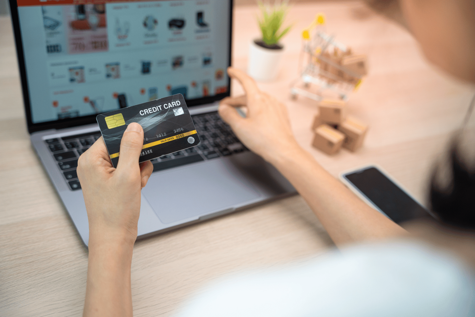 Person using a credit card for Amazon online purchase.