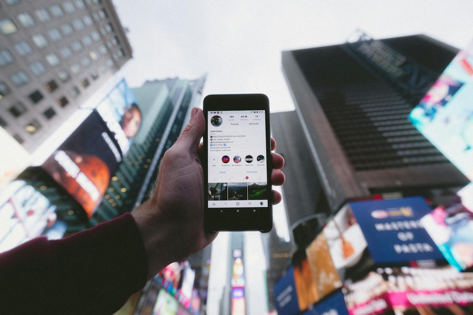 Content creator holding a smartphone with his social media platform profile opened