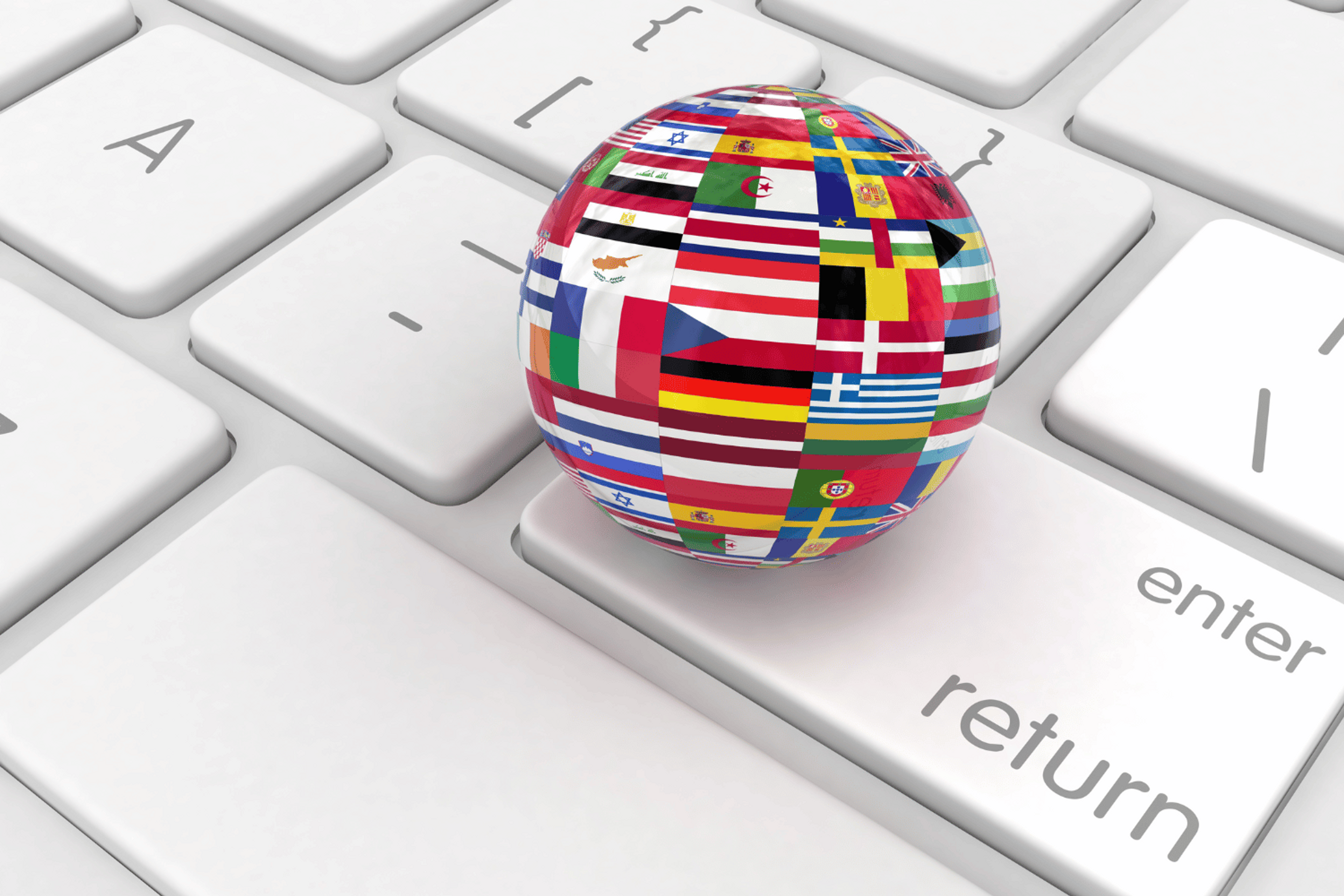 Image of an international globe full of flags placed on a keyboard.