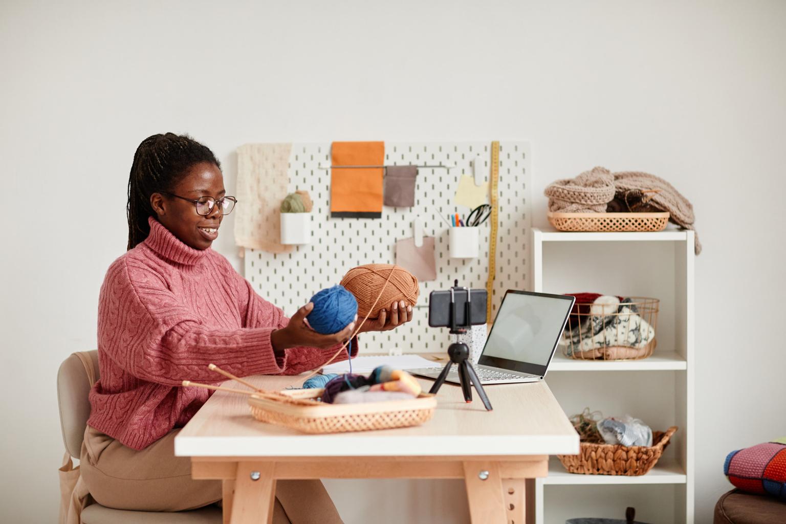 Young woman filming a knitting video for Etsy