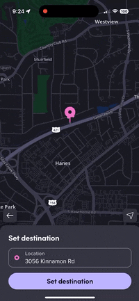 A pink map pin in the Lyft app being picked up and placed at different points along a road. It bounces slightly when placed down.
