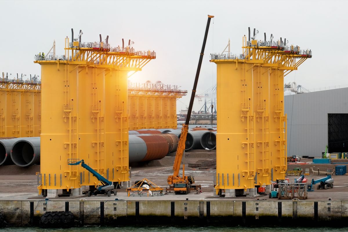 Offshore wind monopiles laid out in a fabrication yard