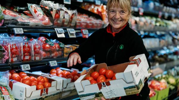 Viser en ansatt i SPAR butikk som plasserer tomater