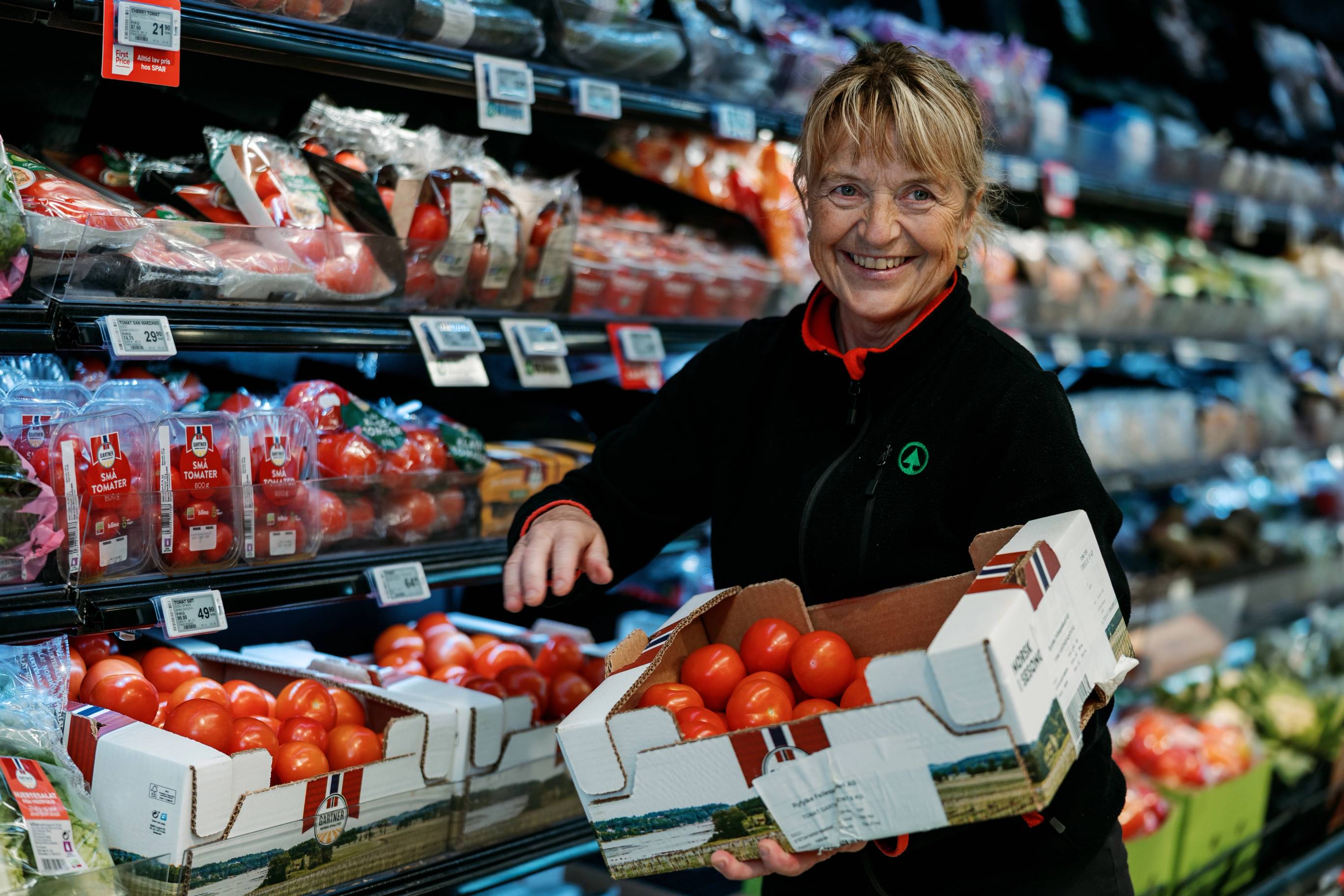 Viser en ansatt i SPAR butikk som plasserer tomater